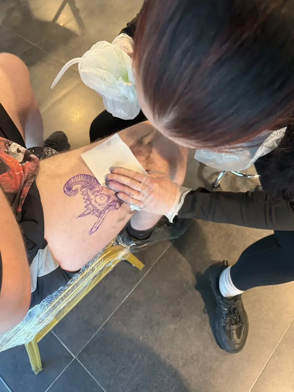 A tutor guiding a student in the Manchester Tattoo College studio